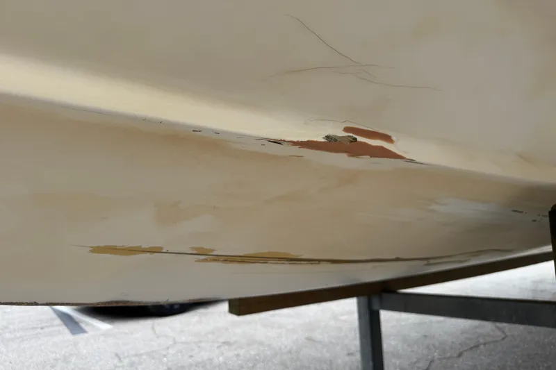 Slide: The Image of Damaged hull of 2006 Dusky 278 boat showing scratches and peeling paint. - 68