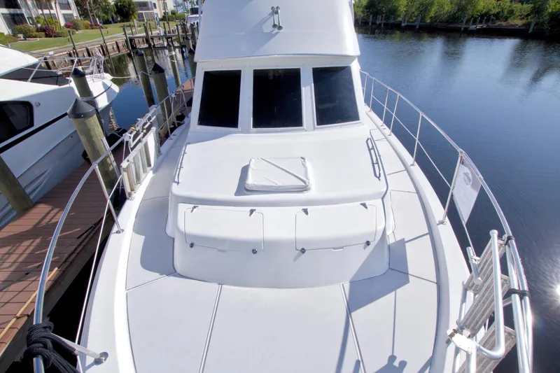 Slide: The Image of 1985 Gulfstar 44 Motor Yacht docked at marina, showcasing sleek white deck design. - 17
