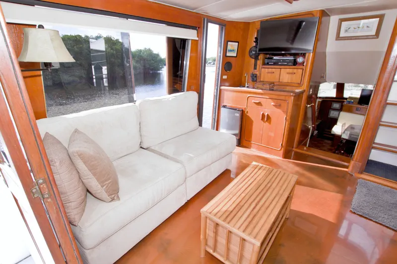 Slide: The Image of 1985 Gulfstar 44 Motor Yacht interior with cozy sofa, wooden decor, and scenic window view. - 25