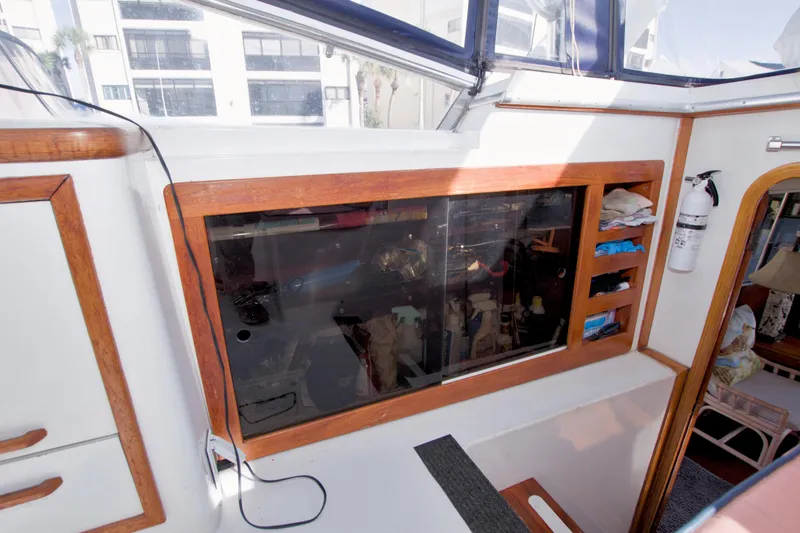 Slide: The Image of 1985 Gulfstar 44 Motor Yacht interior with wooden cabinetry and storage shelves. - 37