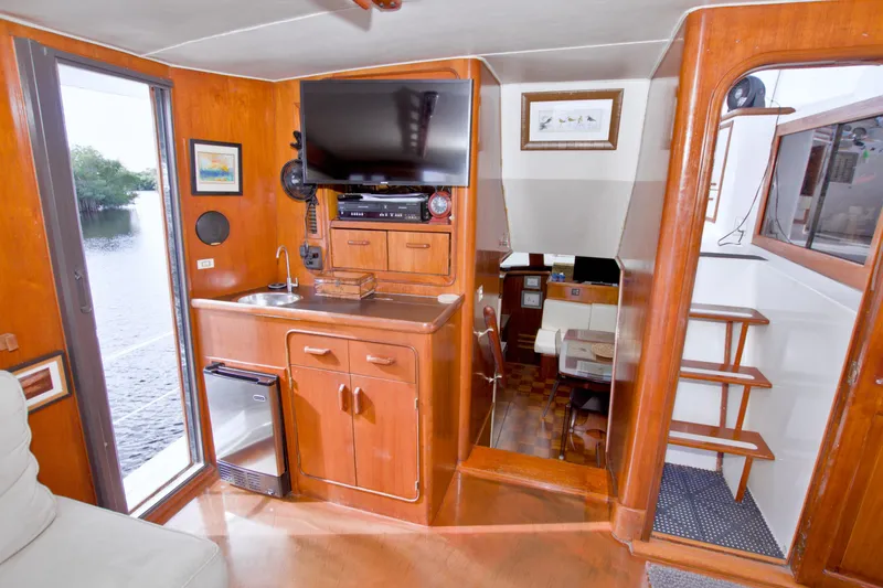 Slide: The Image of 1985 Gulfstar 44 Motor Yacht interior with wood finish, TV, and kitchenette. - 39