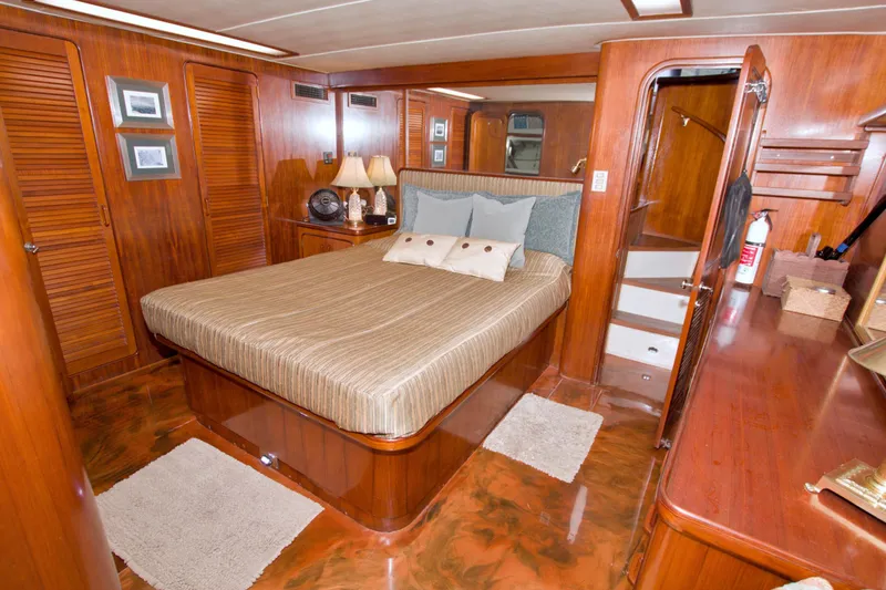 Slide: The Image of Luxurious 1985 Gulfstar 44 Motor Yacht bedroom with wood paneling and elegant decor. - 47
