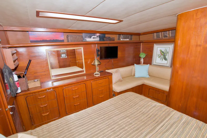 Slide: The Image of 1985 Gulfstar 44 Motor Yacht interior with wood paneling, cozy seating, and decorative accents. - 48
