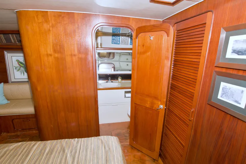 Slide: The Image of 1985 Gulfstar 44 Motor Yacht interior with wooden cabinetry and bathroom view. - 52