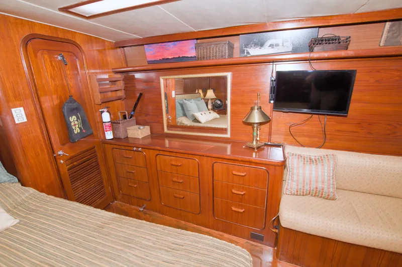Slide: The Image of 1985 Gulfstar 44 Motor Yacht interior with wood cabinetry, mirror, and mounted TV. - 60