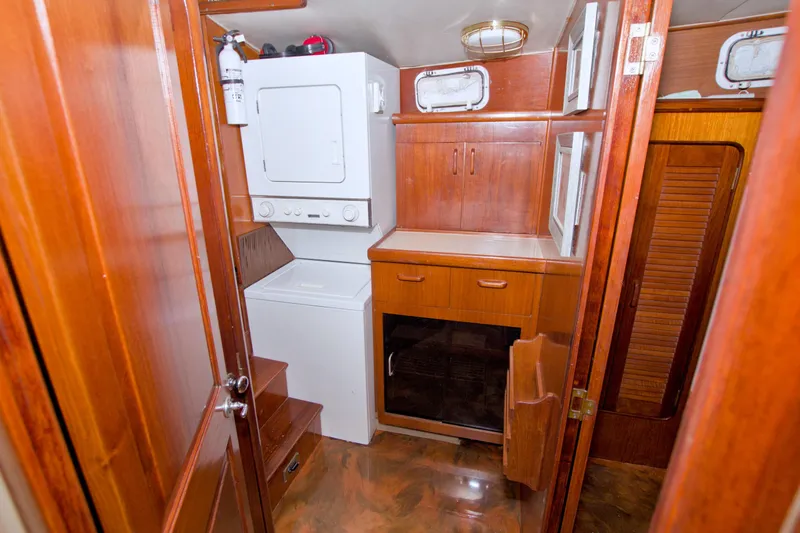 Slide: The Image of 1985 Gulfstar 44 Motor Yacht interior with laundry area and wooden cabinetry. - 63
