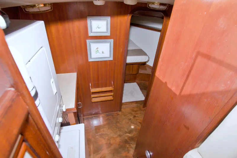 Slide: The Image of Interior of 1985 Gulfstar 44 Motor Yacht with wood paneling and compact laundry area. - 64