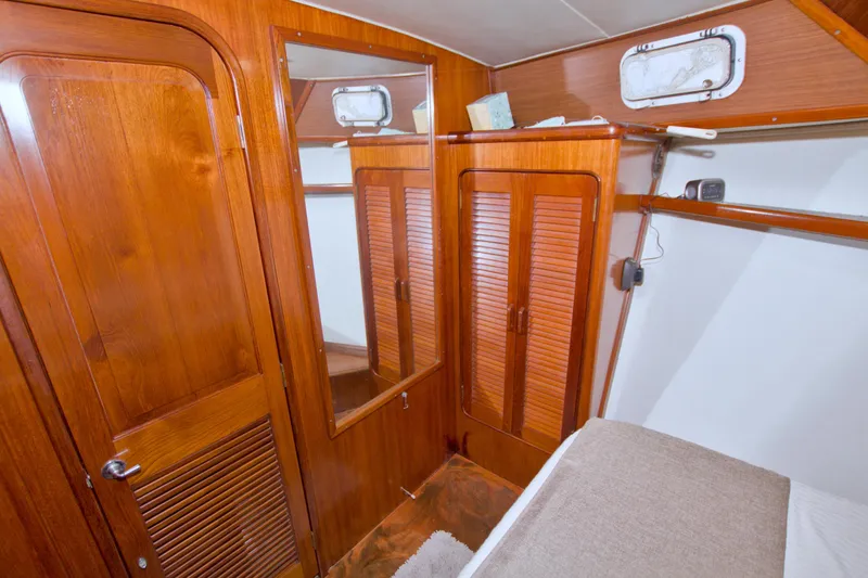 Slide: The Image of 1985 Gulfstar 44 Motor Yacht cabin with wooden interior and storage cabinets. - 68