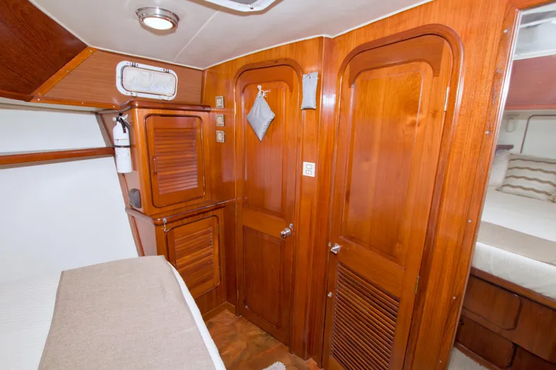 Slide: The Image of 1985 Gulfstar 44 Motor Yacht interior with wooden cabinetry and cozy sleeping quarters. - 69