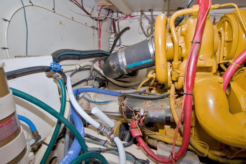 Slide: The Image of Engine room of a 1985 Gulfstar 44 Motor Yacht with visible hoses and machinery. - 84