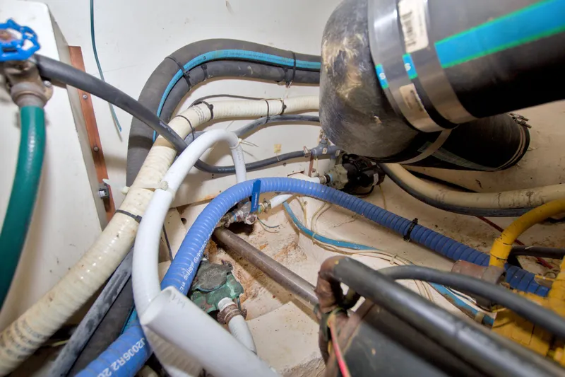 Slide: The Image of Engine room of 1985 Gulfstar 44 Motor Yacht with various hoses and pipes. - 85