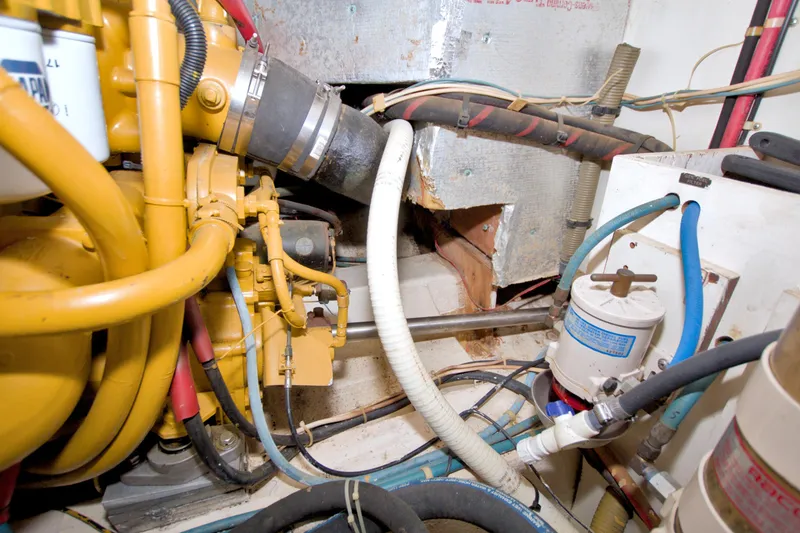 Slide: The Image of Engine room of 1985 Gulfstar 44 Motor Yacht with visible machinery and hoses. - 89
