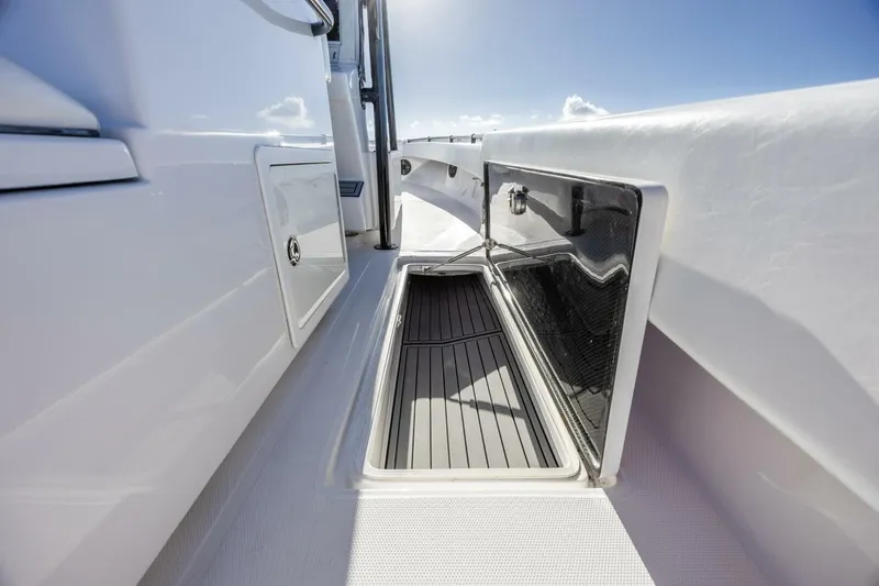 Slide: The Image of 2019 SeaHunter 28 Floridian boat storage compartment with open hatch under clear sky. - 10