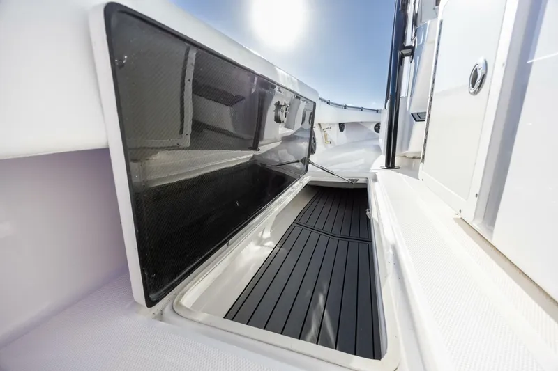 Slide: The Image of 2019 SeaHunter 28 Floridian boat storage compartment, open with sleek black interior. - 11