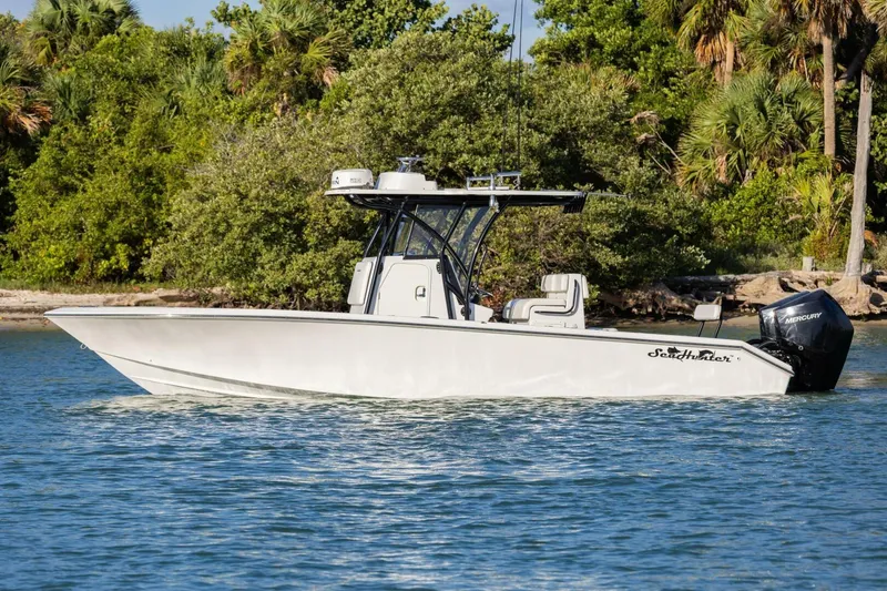 Slide: The Image of 2019 SeaHunter 28 Floridian boat on water, surrounded by lush greenery. - 4
