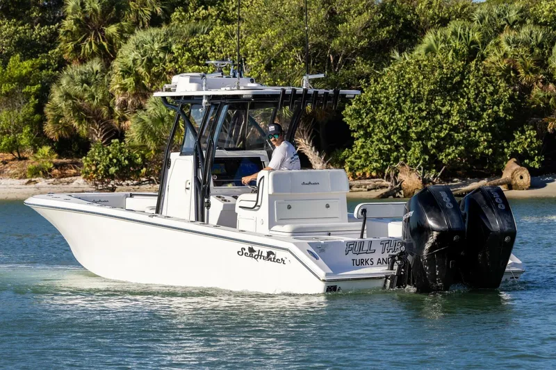 Slide: The Image of 2019 SeaHunter 28 Floridian boat cruising near lush shoreline. - 6