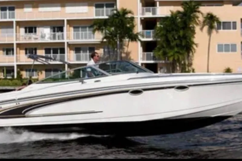 Slide: The Image of 2002 Formula 330 Sun Sport boat cruising near waterfront apartments. - 2