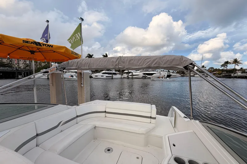 Slide: The Image of 2002 Formula 330 Sun Sport boat with seating, docked near other yachts under a cloudy sky. - 34