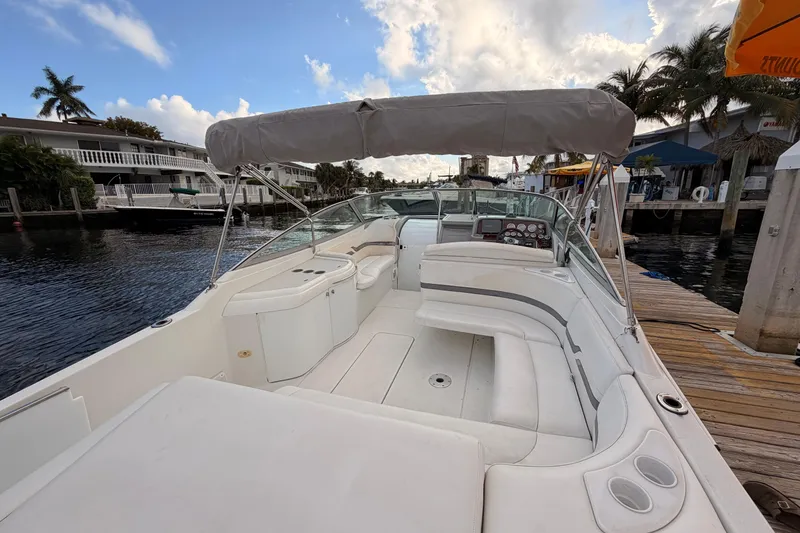Slide: The Image of 2002 Formula 330 Sun Sport boat docked, featuring spacious seating and canopy under a partly cloudy sky. - 35