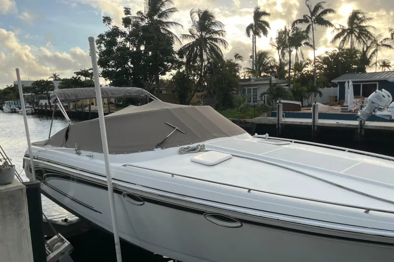 Slide: The Image of 2002 Formula 330 Sun Sport boat docked by palm trees at sunset. - 4