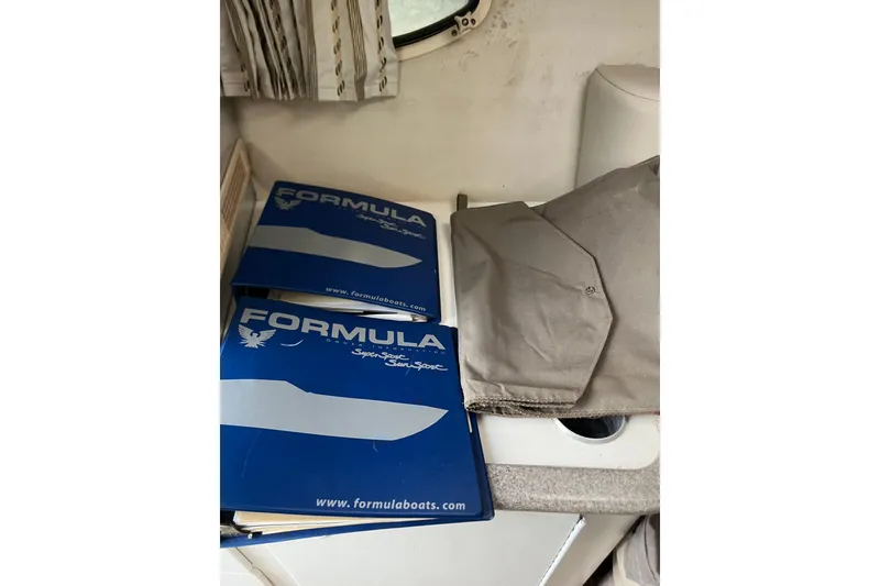 Slide: The Image of 2002 Formula 330 Sun Sport manuals and cover on a boat interior surface. - 53