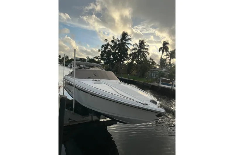 Slide: The Image of 2002 Formula 330 Sun Sport boat docked by palm trees at sunset. - 58