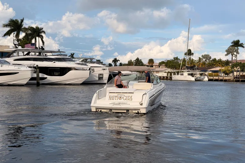 Slide: The Image of 2002 Formula 330 Sun Sport boat cruising in a marina with yachts and palm trees. - 61