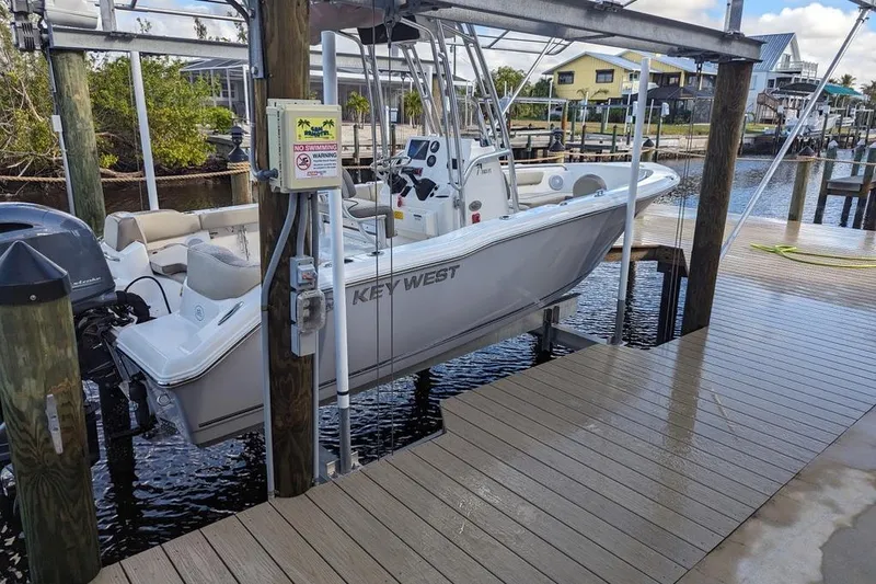 Slide: The Image of 2024 Key West 203 FS boat docked on a wooden pier in a marina setting. - 7