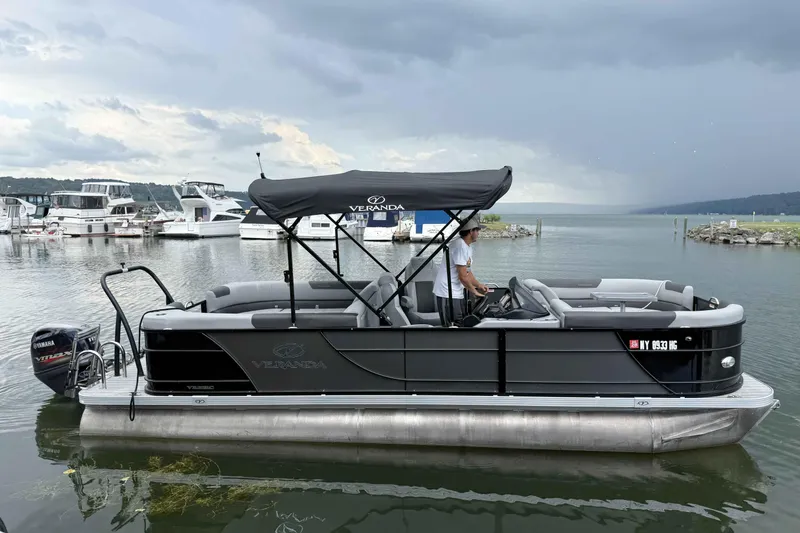 The Image of 2024 Veranda Relax VR22RC pontoon boat on a lake with overcast skies. - 0