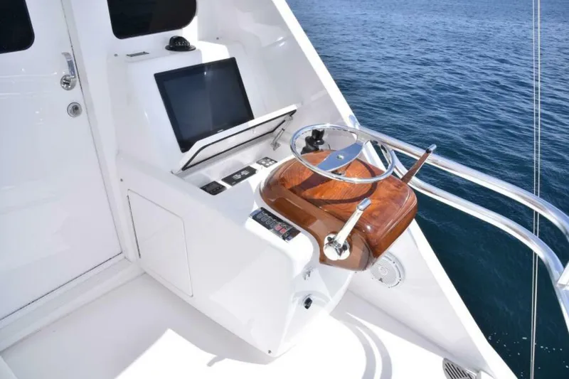 Slide: The Image of 2017 Viking 80 Sky Bridge helm with modern controls and ocean view. - 102