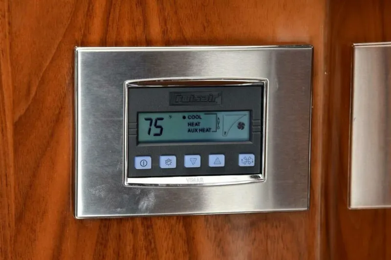 Slide: The Image of Thermostat on 2017 Viking 80 Sky Bridge yacht, displaying 75 degrees on wood panel. - 14