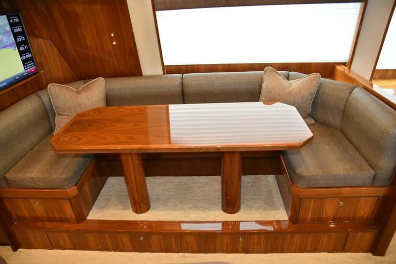 Slide: The Image of Luxurious interior of 2017 Viking 80 Sky Bridge yacht with elegant wood table and cushioned seating. - 25