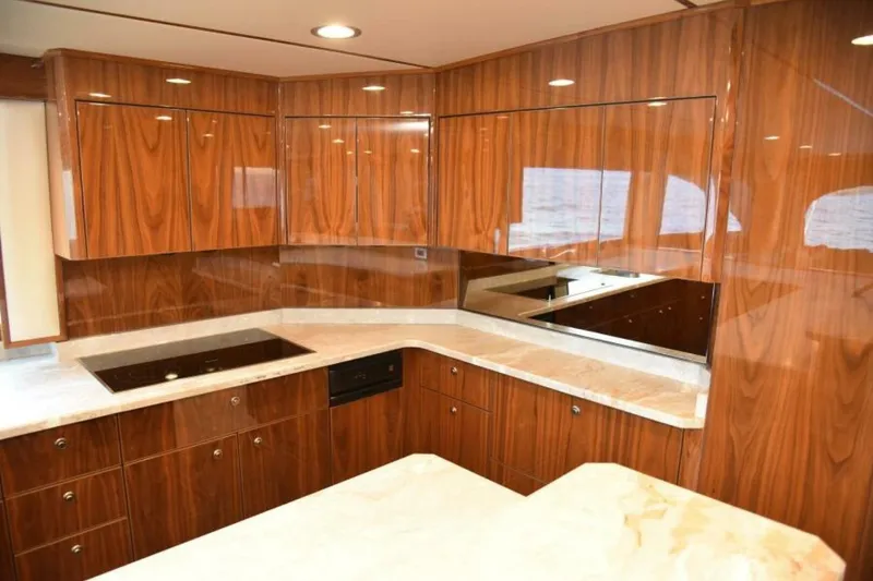 Slide: The Image of Luxurious kitchen interior of 2017 Viking 80 Sky Bridge yacht with wood cabinetry and marble countertops. - 30