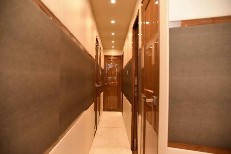 Slide: The Image of Hallway interior of 2017 Viking 80 Sky Bridge yacht with wooden doors and soft lighting. - 39