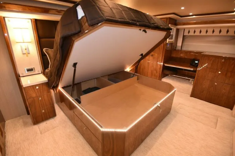 Slide: The Image of Luxurious 2017 Viking 80 Sky Bridge yacht interior with under-bed storage and elegant wood finish. - 40