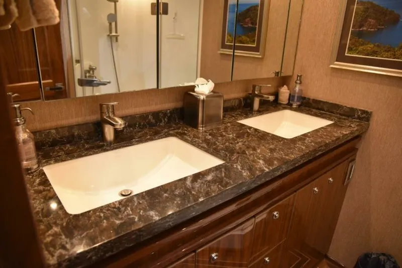 Slide: The Image of Luxurious bathroom in 2017 Viking 80 Sky Bridge yacht with dual sinks and marble countertop. - 50