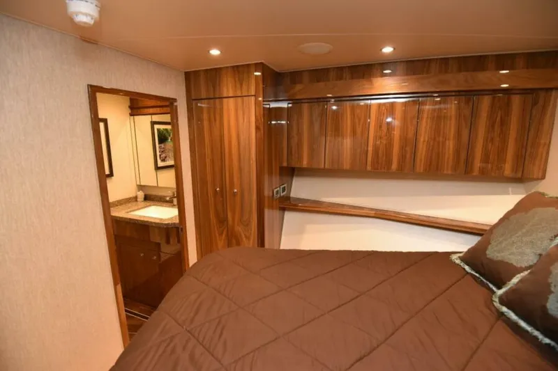 Slide: The Image of Luxurious cabin interior of 2017 Viking 80 Sky Bridge yacht with wood finishes and ensuite bathroom. - 56