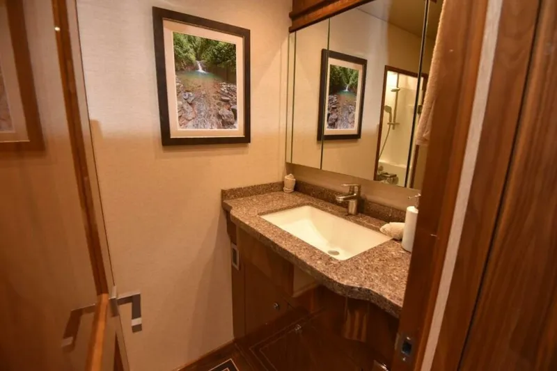 Slide: The Image of Luxurious bathroom in 2017 Viking 80 Sky Bridge yacht with elegant sink and artwork. - 57