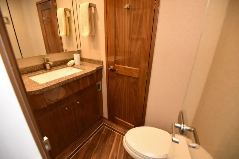 Slide: The Image of Luxurious bathroom in 2017 Viking 80 Sky Bridge yacht with wood accents and modern fixtures. - 58