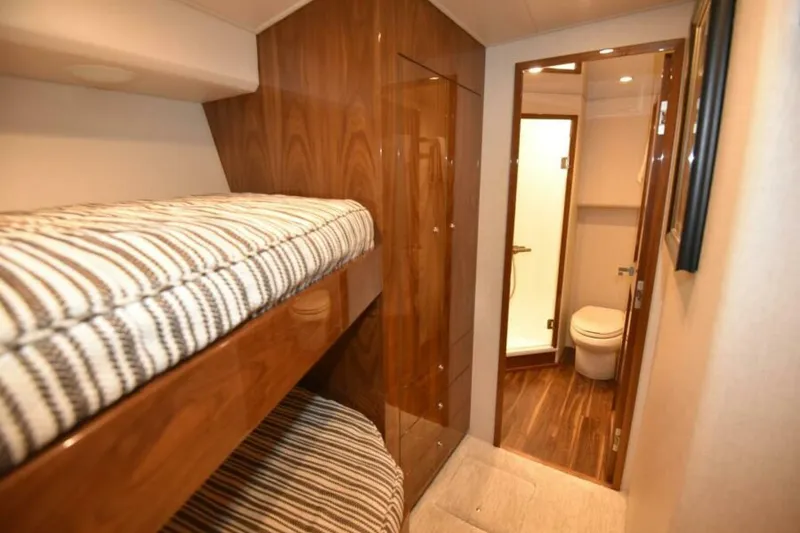 Slide: The Image of 2017 Viking 80 Sky Bridge interior with bunk beds and bathroom. - 63