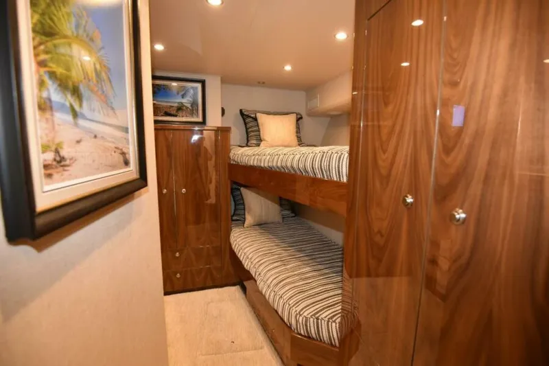 Slide: The Image of Luxurious 2017 Viking 80 Sky Bridge yacht cabin with bunk beds and elegant wood finish. - 64
