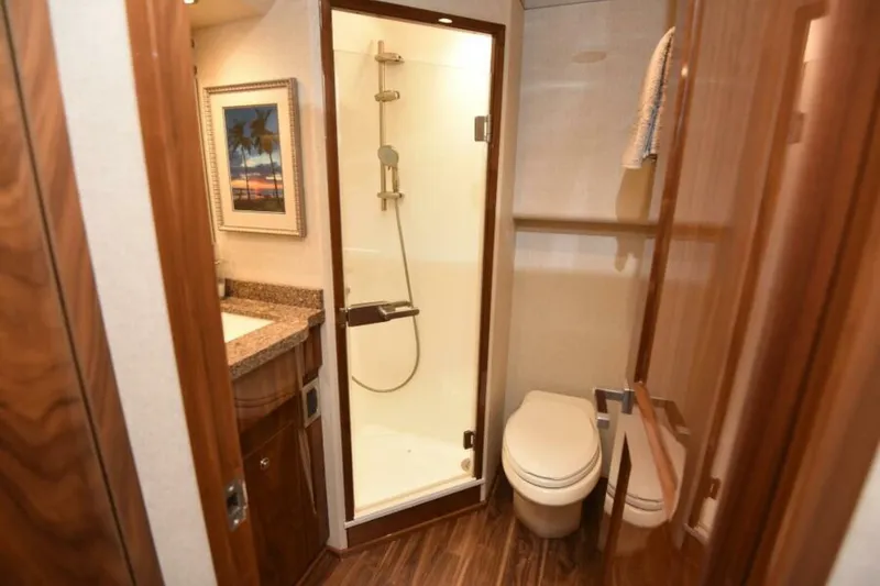 Slide: The Image of Luxurious bathroom in 2017 Viking 80 Sky Bridge yacht with shower and wooden accents. - 65
