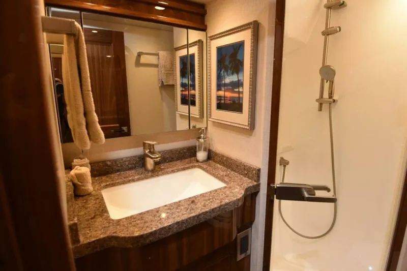Slide: The Image of Luxurious bathroom in 2017 Viking 80 Sky Bridge yacht with granite countertop and modern shower. - 66