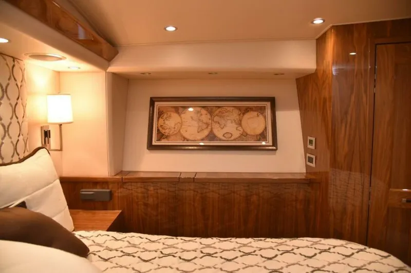 Slide: The Image of Luxurious 2017 Viking 80 Sky Bridge yacht interior with elegant wood paneling and world map decor. - 76