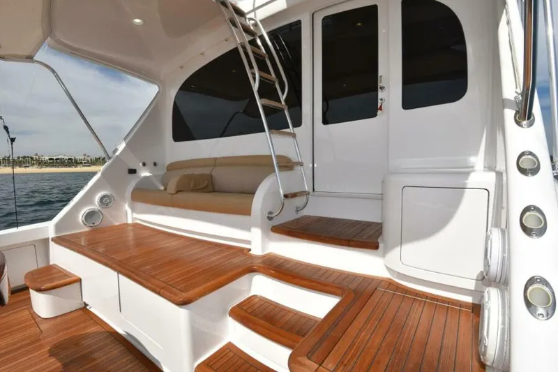 Slide: The Image of Luxurious 2017 Viking 80 Sky Bridge yacht with elegant wooden deck and seating area. - 81