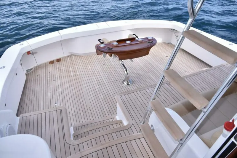 Slide: The Image of 2017 Viking 80 Sky Bridge yacht deck with wooden flooring and ocean view. - 88