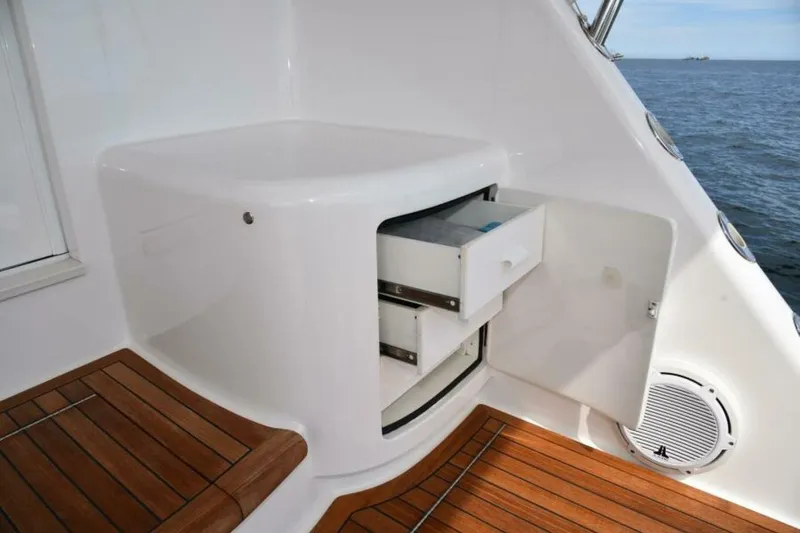 Slide: The Image of 2017 Viking 80 Sky Bridge yacht interior with open storage compartment and ocean view. - 95