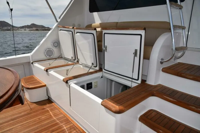 Slide: The Image of 2017 Viking 80 Sky Bridge yacht deck with open storage compartments and wooden steps. - 99