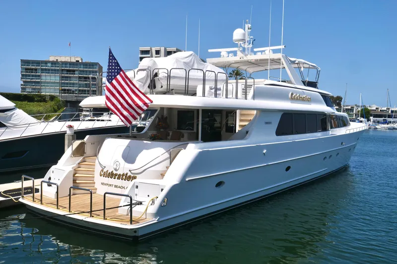 Slide: The Image of Luxury Westport 112 yacht from 2000 docked, featuring American flag and elegant design. - 2