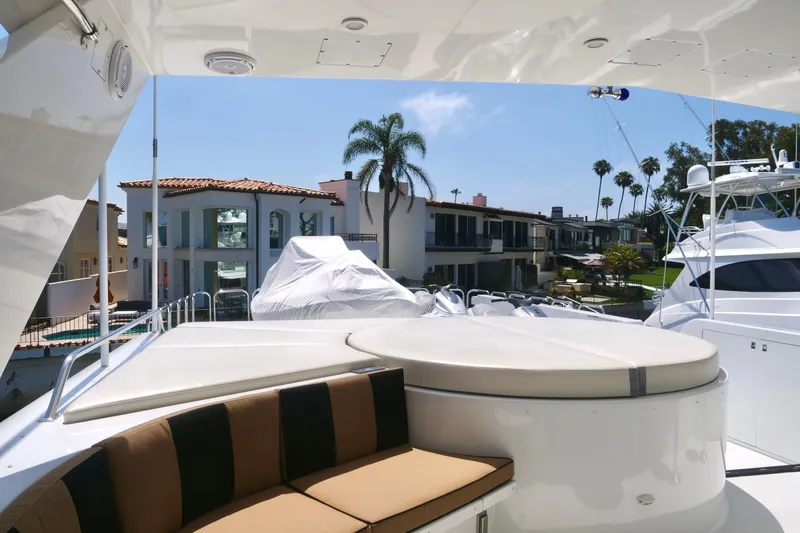 Slide: The Image of Luxurious Westport 112 yacht deck with seating, overlooking waterfront homes and palm trees. - 67